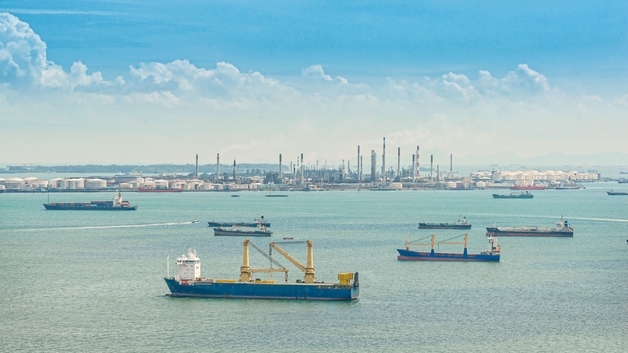 Un puerto con varios barcos y buques cisterna
