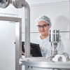 Mujer utilizando una tableta en un entorno industrial higiénico
